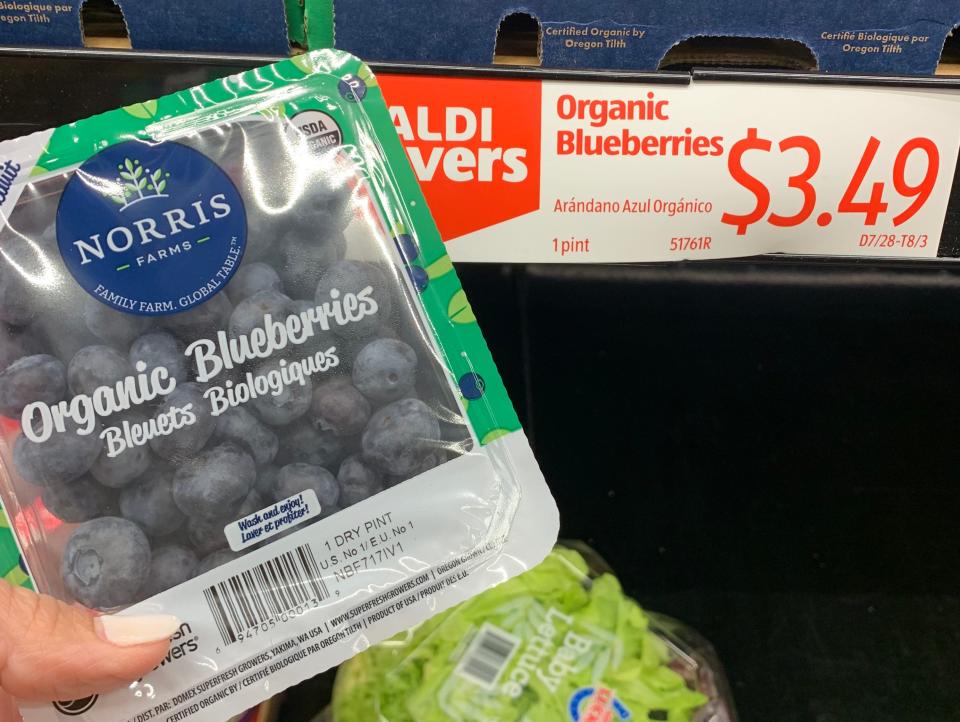 hand holding carton of blueberries at aldi