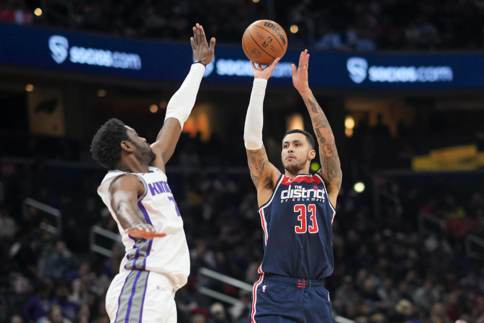 Washington Wizards forward Kyle Kuzma (33) shoots against Sacramento Kings forward Chimezie Metu (7) during the first half of an NBA basketball game Saturday, March 18, 2023, in Washington. (AP Photo/Jess Rapfogel)