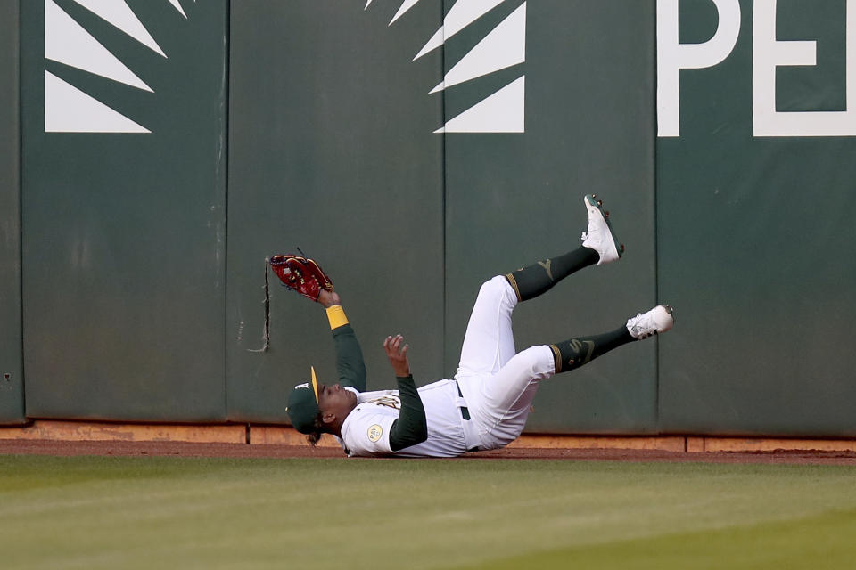 Oakland Athletics' Cristian Pache falls after catching a ball hit by Baltimore Orioles' Kelvin Gutierrez during the second inning of a baseball game in Oakland, Calif., Tuesday, April 19, 2022. (AP Photo/Scot Tucker)