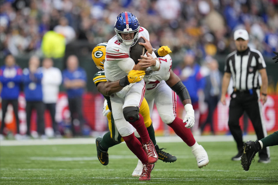 New York Giants linebacker Carter Coughlin (52) tackles New York Giants quarterback Daniel Jones (8) during the second half of an NFL football game at the Tottenham Hotspur stadium in London, Sunday, Oct. 9, 2022. (AP Photo/Kin Cheung)