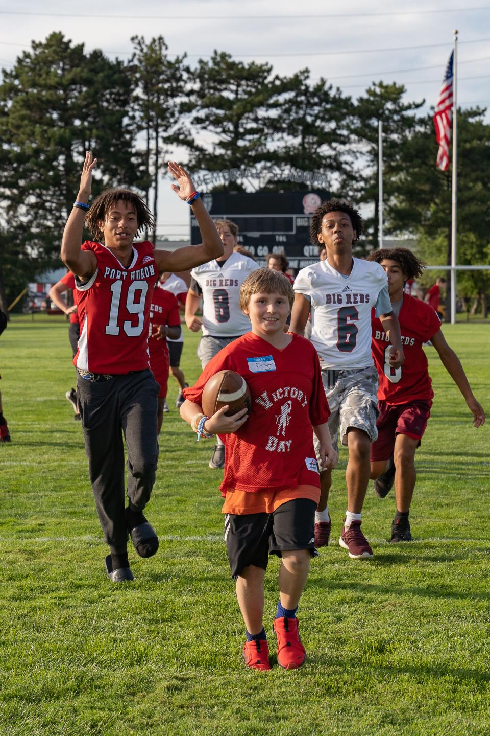 Port Huron football players celebrate as a boy scores a touchdown during Victory Day at Memorial Stadium in Port Huron on Friday, Aug. 12, 2022.