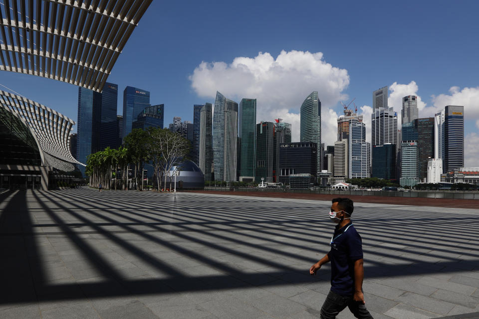 SINGAPORE - APRIL 01:  A man wearing protective mask walks at Marina Bay Sands with the Central Business District seen in the background on April 1, 2020 in Singapore. The Ministry of Health reported 47 new COVID-19 cases, bringing the country's total to 926.  (Photo by Suhaimi Abdullah/Getty Images)