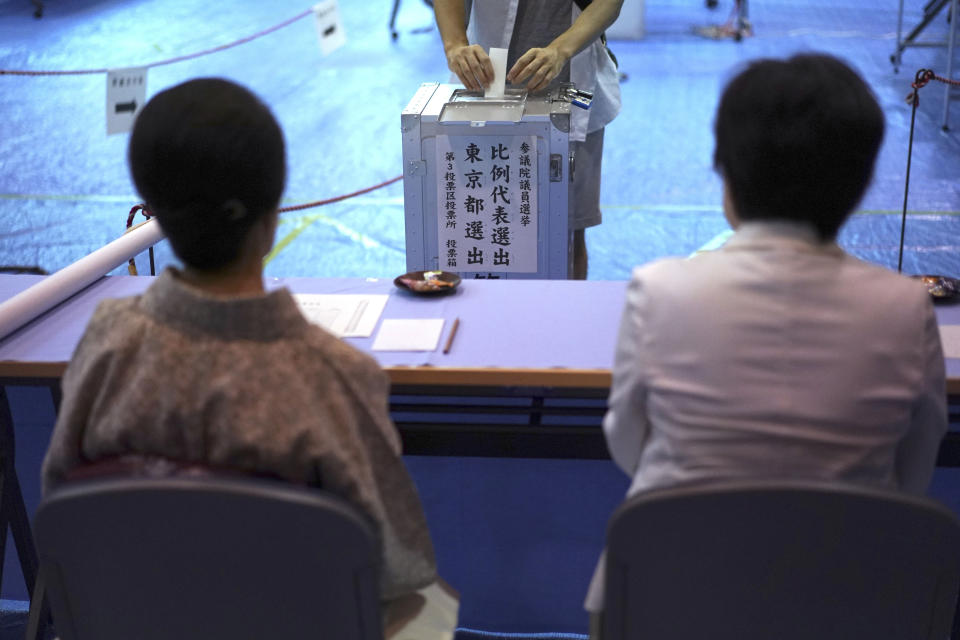 A voter casts a ballot in the upper house elections as representatives of a local election administration commission observe at a polling station in Tokyo Sunday, July 21, 2019. Voting started Sunday morning for the upper house elections where Japanese Prime Minister Shinzo Abe’s ruling coalition is seen to retain majority, according to local media report. (AP Photo/Eugene Hoshiko)