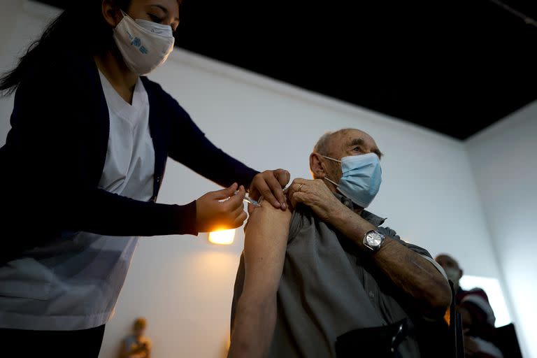 Una enfermera administra una dosis de la vacuna Sputnik V COVID-19 a un anciano en el Parque Tecnopolis, que ha sido reutilizado como centro de vacunas, en Buenos Aires, Argentina. (AP Foto/Víctor R. Caivano )