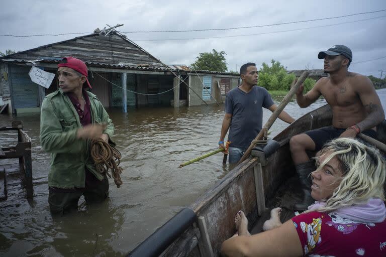 Vecinos conversan en una calle inundada tras el paso del huracán Helene en Guanimar, provincia de Artemisa, Cuba, el miércoles 25 de septiembre de 2024.