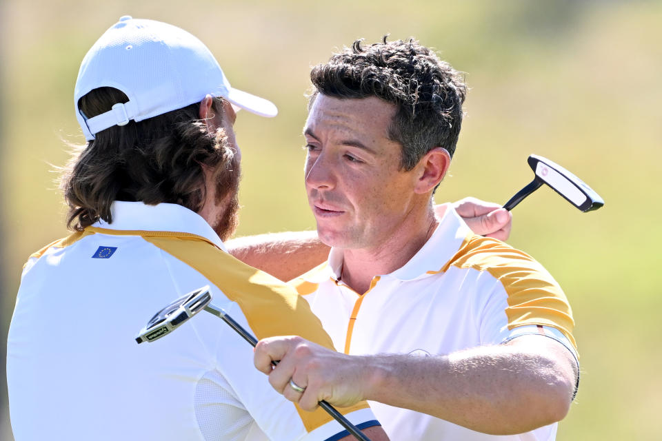 Rory McIlroy embraces Tommy Fleetwood of Team Europe on the 18th green after finishing their practice round prior to the 2023 Ryder Cup at Marco Simone Golf Club on September 26, 2023, in Rome, Italy. (Photo by Ross Kinnaird/Getty Images)