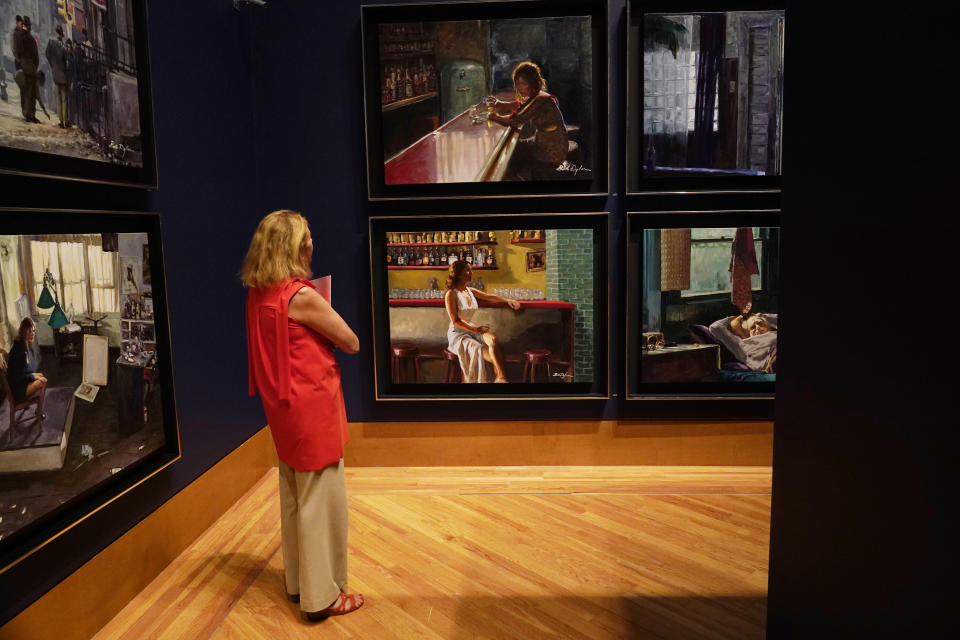 Jordana Pomeroy, director of the Patricia & Phillip Frost Art Museum, looks at a new series of paintings called "Deep Focus" by Bob Dylan, at Florida International University, Tuesday, Nov. 23, 2021, in Miami. Dylan, America's lyricist and Noble laureate, will exhibit more than 180 acrylics, watercolors, drawings and ironwork sculptures in the exhibit "Retrospectrum", which runs from Nov. 30- April 17. (AP Photo/Marta Lavandier)