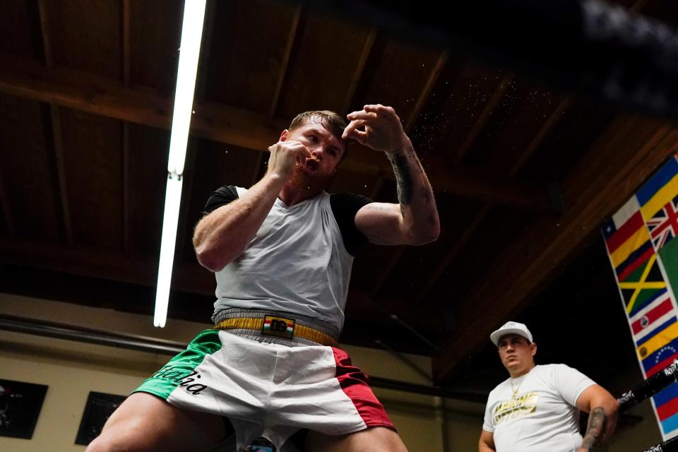 Unified WBC/WBO/WBA super middleweight champion Canelo Alvarez trains as trainer Eddy Reynoso looks on, right, at a gym Wednesday, Oct. 20, 2021, in San Diego. Alvarez faces undefeated IBF Super Middleweight Champion Caleb Plant in a fight Nov. 6 in Las Vegas. (AP Photo/Gregory Bull)