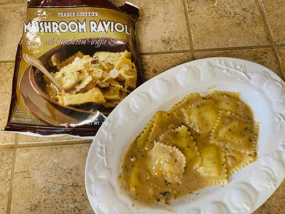 Bag of trader joe's mushroom ravioli beside cooked white plate of it