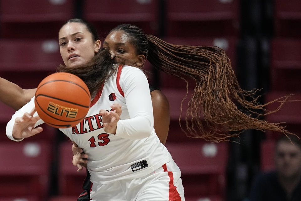 San Diego State guard Meghan Fiso, left passes the ball as Stanford forward Kiki Iriafen defends during the first half of an NCAA college basketball game, Friday, Dec. 1, 2023, in San Diego. (AP Photo/Gregory Bull)