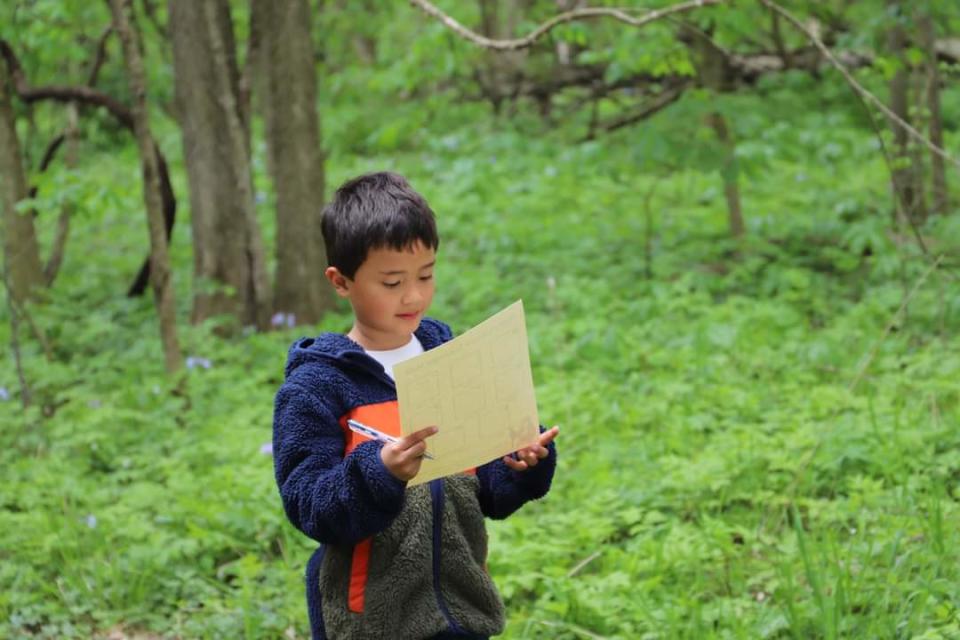 A child participates in a scavenger hunt at Red-tail Land Conservancy's Phyllis and Frank Yuhas Woods.