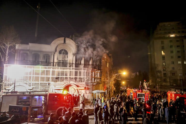 Se levanta humo mientras manifestantes iraníes prenden fuego a la embajada saudí en Teherán, domingo 3 de enero de 2016.