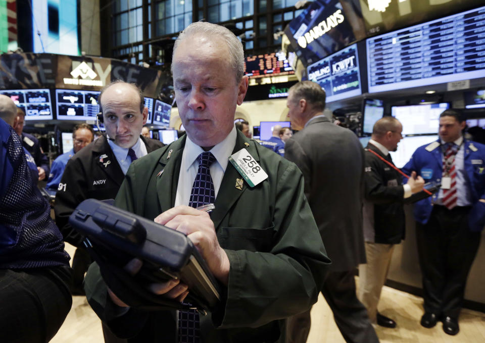 Trader James Riley, center, works on the floor of the New York Stock Exchange, Tuesday, April 8, 2014. Stocks were mixed in early trading on Tuesday after a three-day slump. Investors will start to focus on company earnings this week. (AP Photo/Richard Drew)