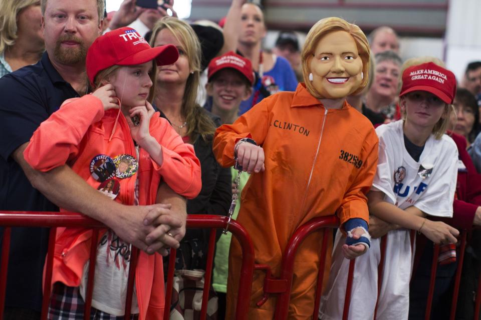 Supporters of Republican presidential candidate Donald Trump, one wearing a mask of Democratic presidential candidate Hillary Clinton, wait for his arrival to a campaign rally at the Jefferson County Fairgrounds, Saturday, Oct. 29, 2016, in Golden, Colo. (AP Photo/ Evan Vucci)