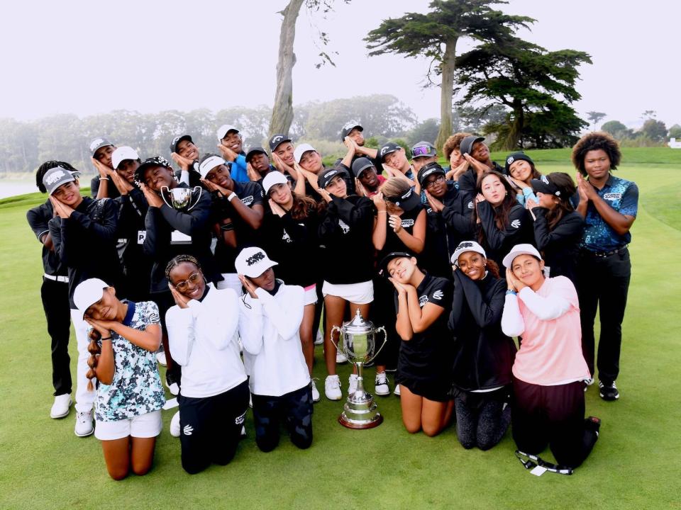 A group of golfers including Stephen Curry pose by resting their head on their hands at a golf event.