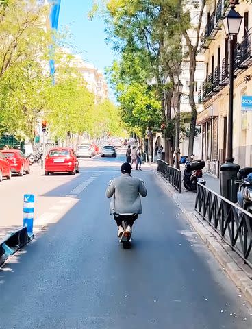 <p>Tom Brady/Instagram</p> Tom Brady crouches down as he rides an electric scooter around Madrid