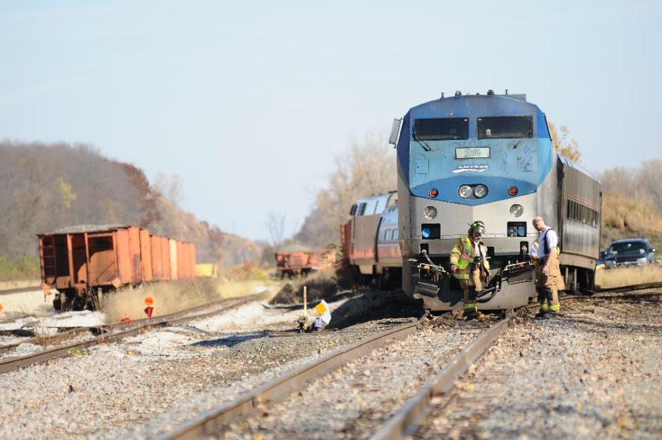 Firefighters inspect the scene of a train derailment just North of Niles, Mich., Sunday, Oct. 21, 2012. About a dozen passengers and crew on an Amtrak train from Chicago to Pontiac, north of Detroit, were injured when two of its locomotives and one or more coaches derailed. (AP Photo/Joseph Weiser) MANDATORY CREDIT