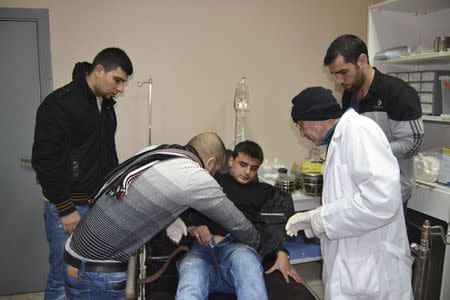 An injured man receives treatment at a hospital after a suicide bomb attack took place in Jabal Mohsen, Tripoli, January 10, 2015. REUTERS/Stringer