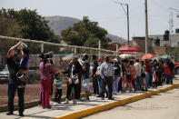 Residents wait in line for a chance to try out a new public transit system dubbed the Cablebus, outside the Campos Revolucion station in the Cuautepec neighborhood of northern Mexico City, Thursday, March 4, 2021. For the residents of Cuautepec, this new system, the first of four planned lines, will turn a commute to the nearest subway station, that can last up to two hours, into a 30-minute ride. (AP Photo/Rebecca Blackwell) northern Mexico City, Thursday, March 4, 2021. (AP Photo/Rebecca Blackwell)