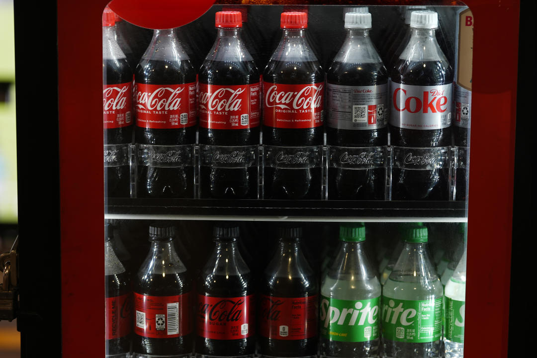 Bottles of Coca Cola are displayed in a case in Coors Field before fans arrive to watch the Colorado Rockies host the Seattle Mariners Friday, April 19, 2024, in Denver. (AP Photo/David Zalubowski)