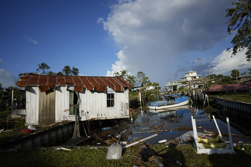 FILE - A cottage belonging to the Ellison family teeters over a canal, alongside the remnants of the family's destroyed business, Ed's Baithouse and Marina, in Horseshoe Beach, Fla., Thursday, Aug. 31, 2023, one day after the passage of Hurricane Idalia. Buddy Ellison said five generations of his family have lived on this property, and while their stilted home remains, rebuilding the business and cottage on stilts as required would be cost prohibitive. (AP Photo/Rebecca Blackwell, File)