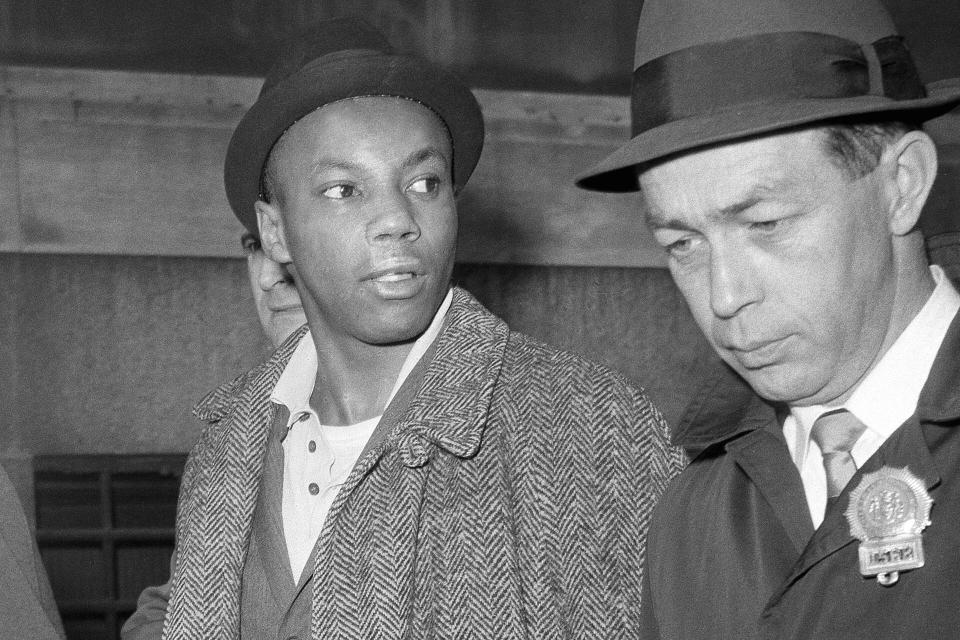 FILE - Muhammad Aziz, a suspect in the slaying of Malcolm X, is escorted by detectives at police headquarters after his arrest in New York on Feb. 26, 1965. Aziz, 84, has filed a $40 million lawsuit against New York City for the two decades he spent in prison for a notorious crime he did not commit. (AP Photo, File)