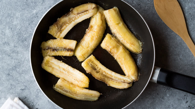 Halved caramelized bananas in a frying pan
