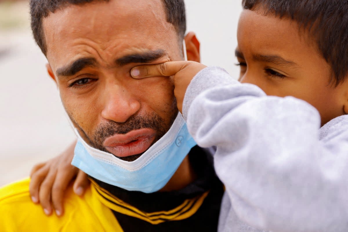 Saul, 4, wipes the tears of his father Franklin Pajaro, after they were expelled from the US and sent back to Mexico under Title 42 (Reuters)