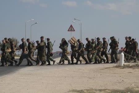 Russian marines cross a road in the Crimean port of Sevastopol, September 17, 2014. REUTERS/Pavel Rebrov