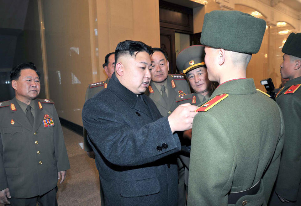 This undated photo released by North Korea's official Korean Central News Agency via the Korean News Service on March 25, 2013 shows North Korean leader Kim Jong-Un (C) looking at the samples of overcoats at an undisclosed location in North Korea.