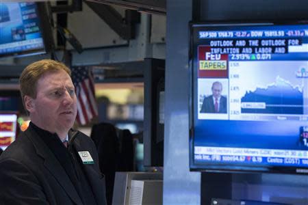 A trader listens to an announcement by the U.S. Federal Reserve on the floor of the New York Stock Exchange in New York December 18, 2013. REUTERS/Lucas Jackson