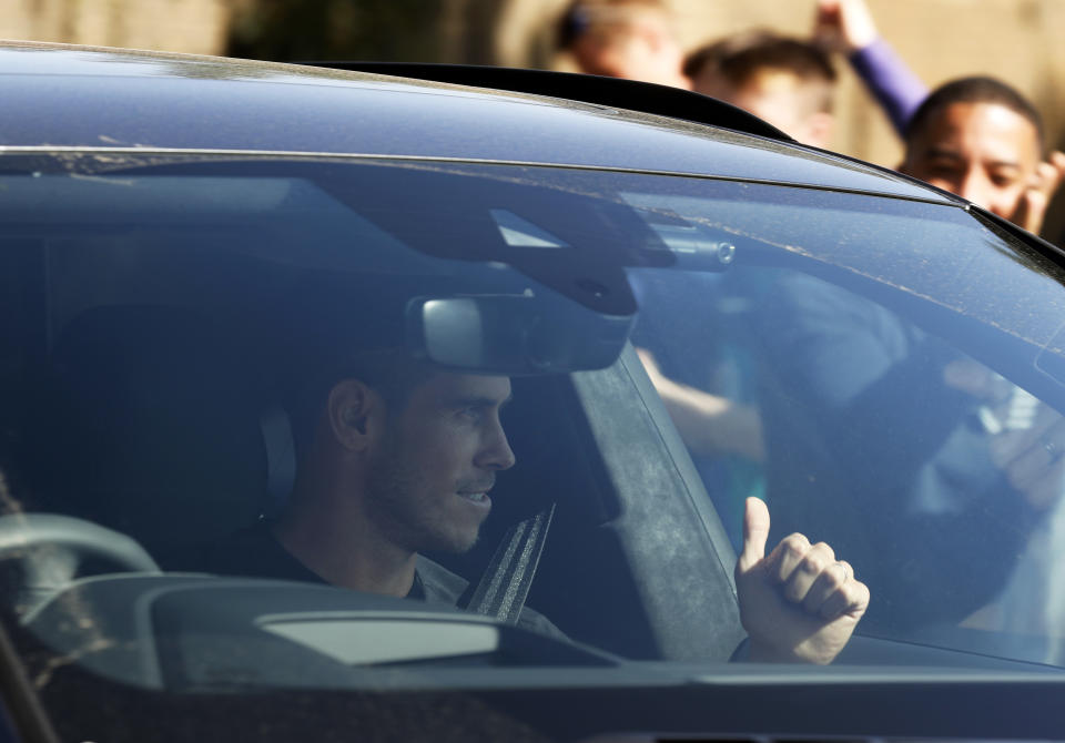 Soccer player Gareth Bale gestures to fans as he arrives at the training ground of Tottenham Hotspur in London, Friday Sept. 18, 2020. Real Madrid winger Gareth Bale is in London to complete his return to Tottenham. Bale left Tottenham for Madrid in 2013 for 100 million euros. (AP Photo/Frank Augstein)