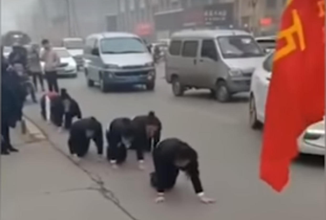 Trabajadoras chinas obligadas a arrastrarse en medio de la calle por no cumplir las metas anuales de la empresa (Captura de pantalla de video viral)