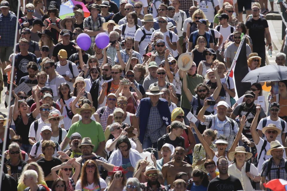 People mostly without face masks attend a demonstration with the slogan ‚The end of the pandemic - freedom day' - against coronavirus restrictions in Berlin, Germany, Saturday, Aug. 1, 2020. It comes amid increasing concern about an upturn in infections in Germany. (AP Photo/Markus Schreiber)