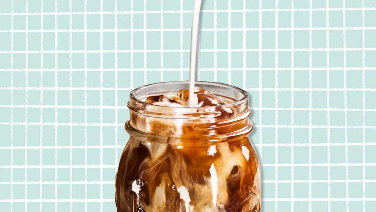 milk pouring into an iced coffee on a designed background