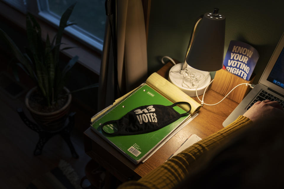 A mask decorated with the Detroit area code belonging to Clare Allenson, civic engagement director for Michigan League of Conservation Voters which works on voter outreach and resources as well as recruitment of poll workers for the upcoming election, sits on her desk as she works from home in Detroit, Thursday, Oct. 29, 2020. (AP Photo/David Goldman)