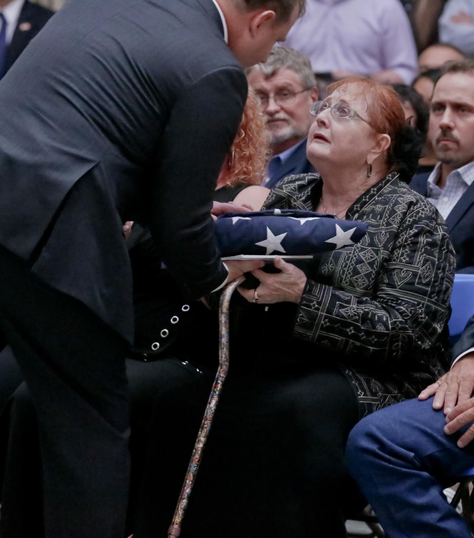 Rebecca Crofts accepts a folded American flag in honor of her father, World War II Staff Sgt. Bernard Snow, during a ceremony recognizing National Purple Heart Day, Monday Aug. 7, 2017, at Federal Hall in New York. The ceremony reunited families with previously lost Purple Hearts belonging to war veterans. (AP Photo/Bebeto Matthews)