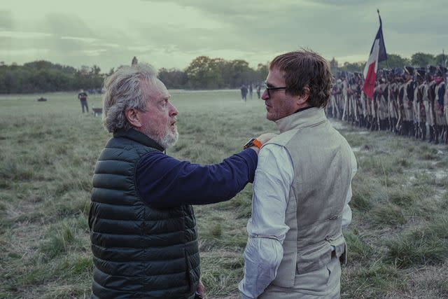 <p>Aidan Monaghan/Apple TV+</p> Ridley Scott and Joaquin Phoenix on "Napoleon" set.