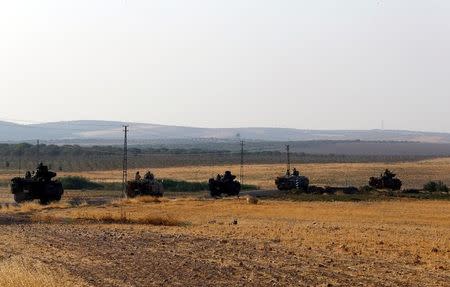Turkish armoured personnel carriers drive towards the border in Karkamis on the Turkish-Syrian border in the southeastern Gaziantep province, Turkey, August 27, 2016. REUTERS/Umit Bektas