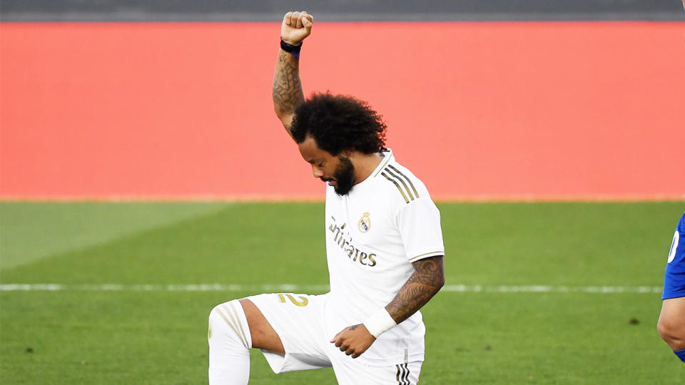 Real Madrid's Brazilian defender Marcelo kneels on the field to celebrate his goal during the La Liga.(Photo by PIERRE-PHILIPPE MARCOU/AFP via Getty Images)