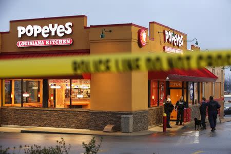 Police officers search for evidence in the shooting death of a Prince George's County Police officer at a Popeye's chicken restaurant near the primary crime scene where the officer was shot in Landover, Maryland March 13, 2016. REUTERS/Jonathan Ernst