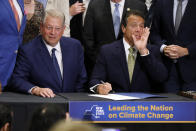 New York Gov. Andrew Cuomo, right, accompanied by former Vice President Al Gore, announces that he is signing the Climate Leadership and Community Protection Act, Thursday, July 18, 2019, at Fordham University in New York. New York’s new law aimed at ending climate change emissions will drive dramatic changes over the next 30 years if it meets its ambitious goals. (AP Photo/Richard Drew)