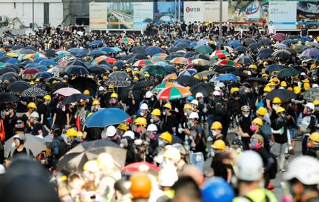 Protesters carry umbrellas as they attends a demonstration in support of the city-wide strike and to call for democratic reforms in Hong Kong