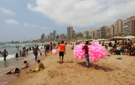 A man sells cotton candy at Ramlet al-Bayda public beach in Beirut