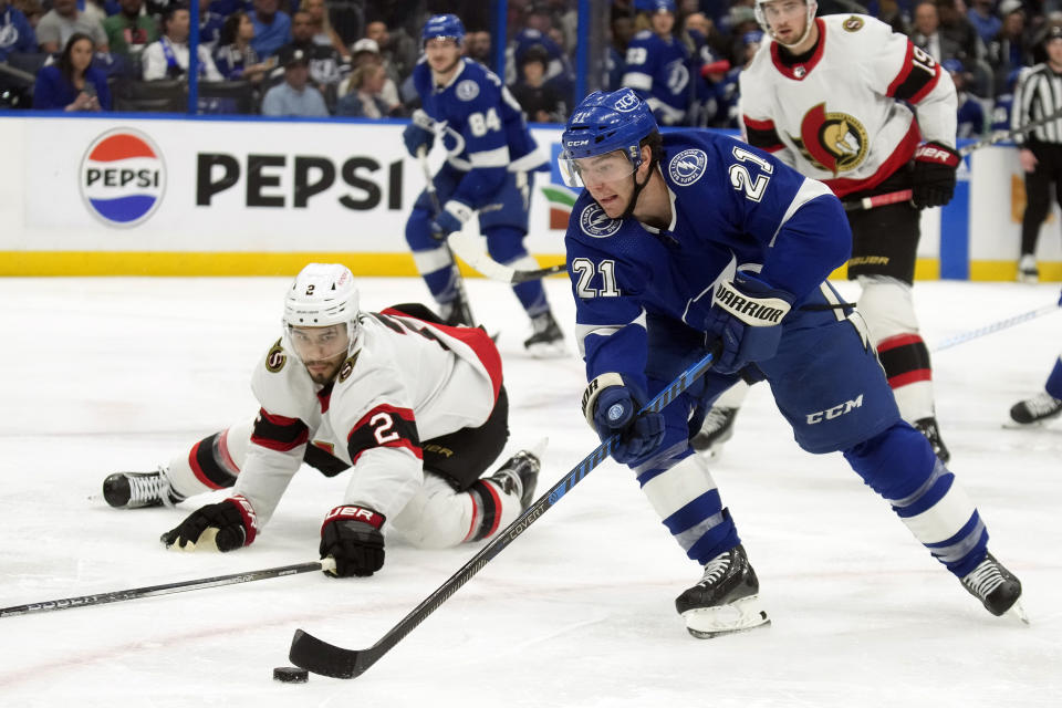 Tampa Bay Lightning center Brayden Point (21) gets around Ottawa Senators defenseman Artem Zub (2) during the second period of an NHL hockey game Thursday, April 11, 2024, in Tampa, Fla. (AP Photo/Chris O'Meara)