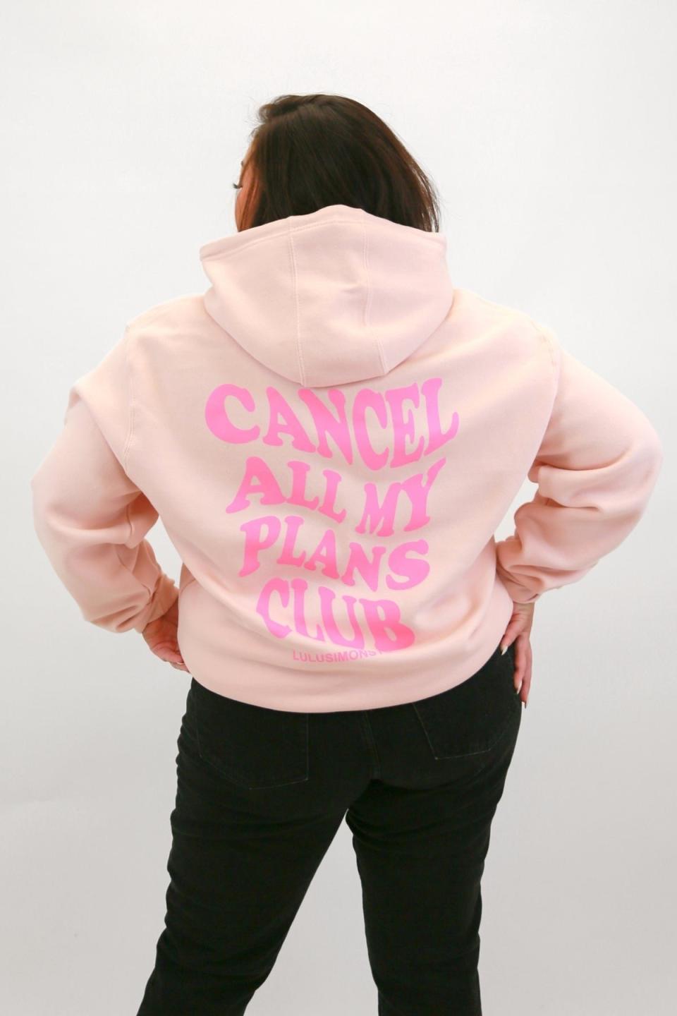 model wearing light pink sweatshirt with the phrase 