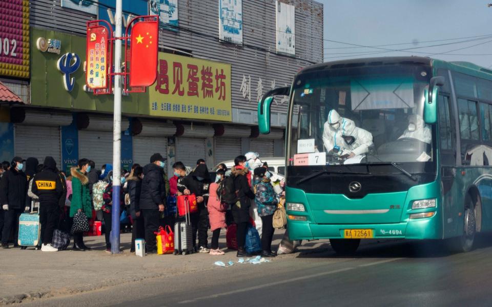 Residents line up to get on a bus at Gaocheng district to be taken to centralized quarantine in Shijiazhuang - STR/CNS/AFP via Getty Images