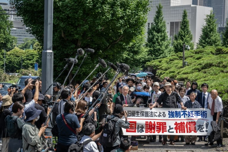 Lawyers and supporters of victims of forced sterilisation under a now-defunct eugenics law, carrying a banner demanding apologies and compensations, march toward the Supreme Court of Japan in Tokyo (Yuichi YAMAZAKI)