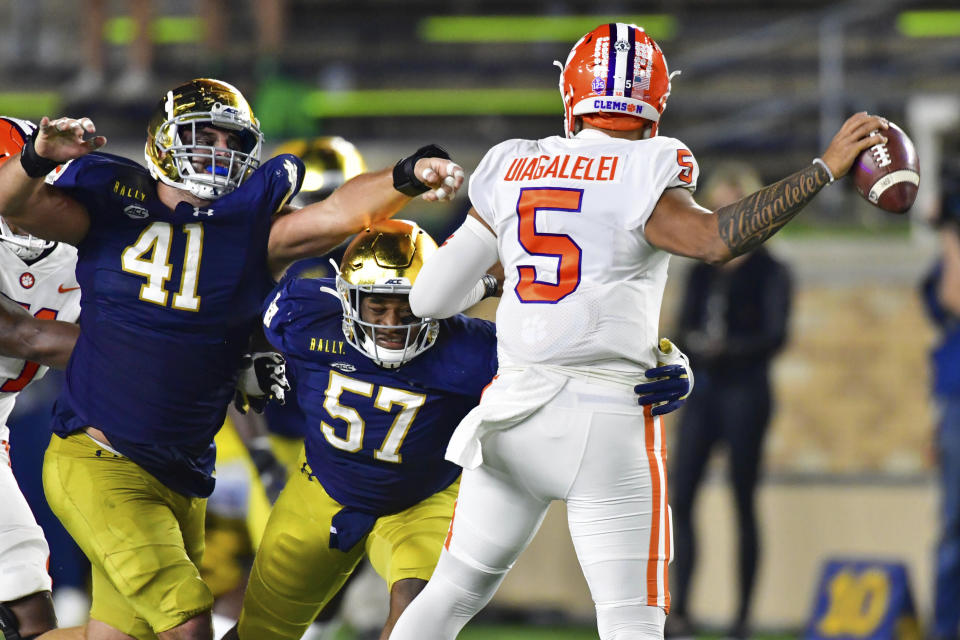 Notre Dame defensive linemen Kurt Hinish (41) and Jayson Ademilola (57) pressure Clemson quarterback D.J. Uiagalelei (5) during the third quarter of an NCAA college football game Saturday, Nov. 7, 2020, in South Bend, Ind. (Matt Cashore/Pool Photo via AP)