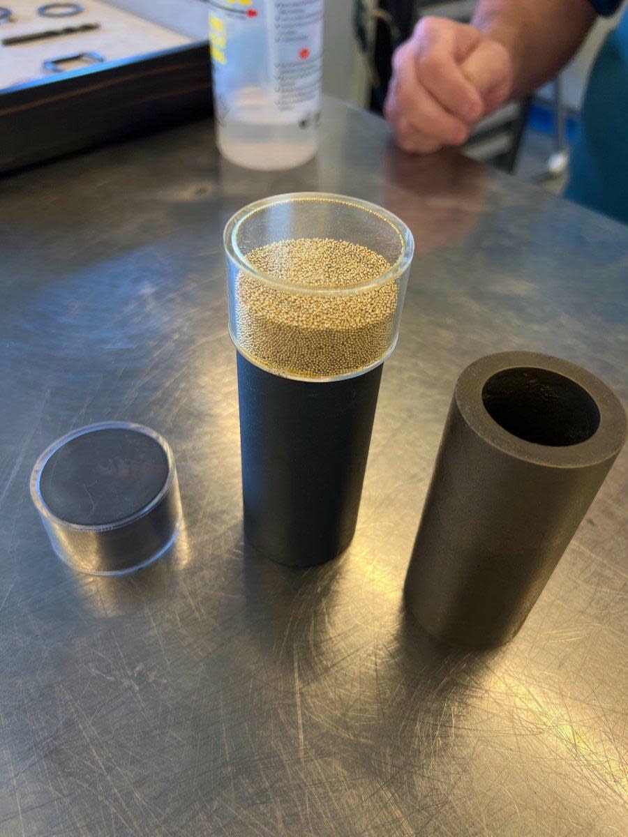 用來製作Magic Gold魔力金材質的原料，包括黑色的碳化硼陶瓷，與24K純金金粒。而右側就是將二者合而為一的魔力金材質。